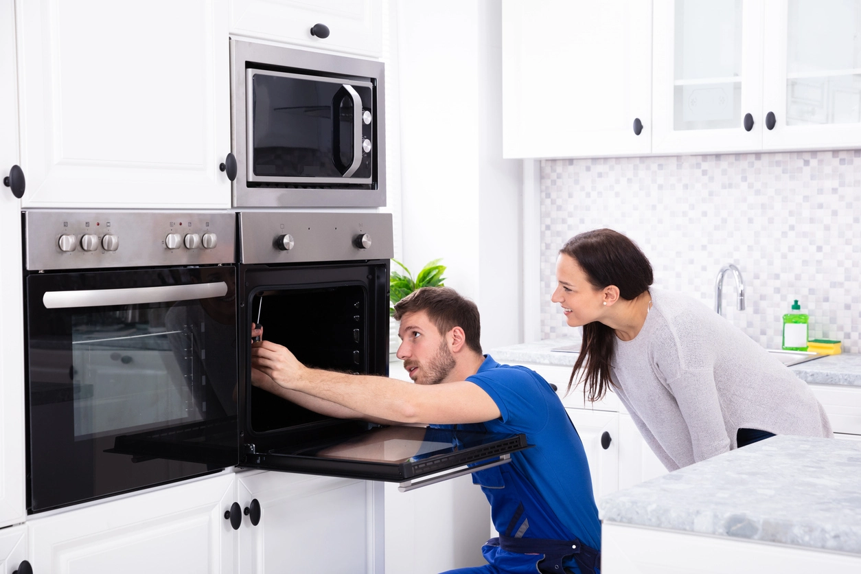 Tecnico revisando un horno Domec con una clienta